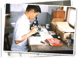 林慶和透過顯微鏡看檢體。